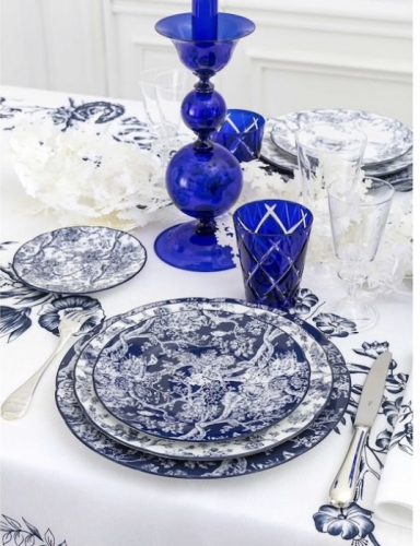 Conjunto de pratos azul a branco, copo azul e castiçal em vidro azul, da marca francesa Dior