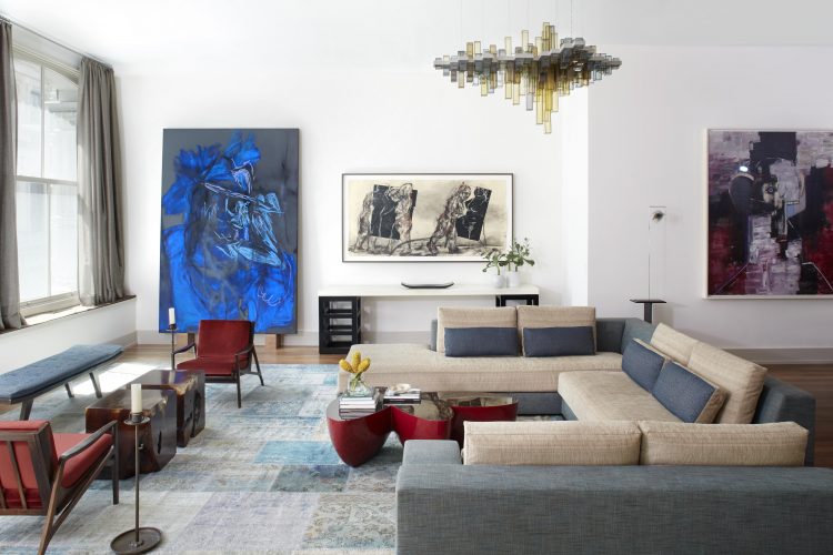 Loft em NY, sala com sofás cinza e paredes com obras de arte
