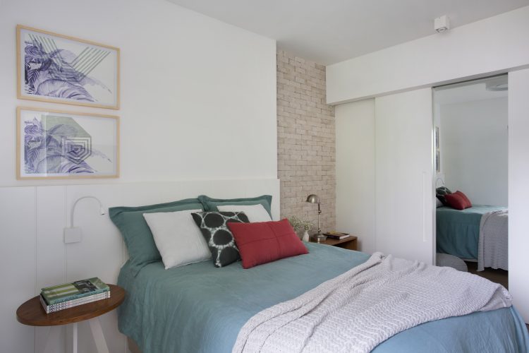Pequenas interferências para tornar os ambientes mais amplos em um apartamento no Leblon. Parede lateral da cama em tijolinho pintado de branco