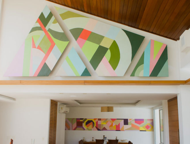 Telas em formatos diferentes coloridas com desenhos geométricos na parede  interior de uma casa