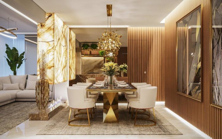 Sofisticação em apartamento com 100m². Sala de jantar com mesa dourada, painel em mármore e paredes com madeira ripada