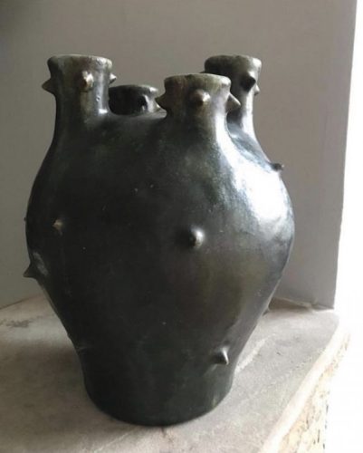 um vaso em cerâmica com quatro bocas e bolotas no corpo 