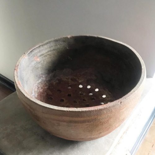 um bowl antigo em cerâmica e furos no fundo