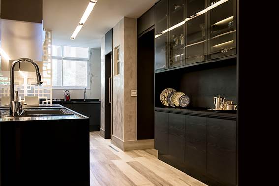 Cozinha, muito prazer. Cozinha com planta corredor, piso em madeira, e armários pretos