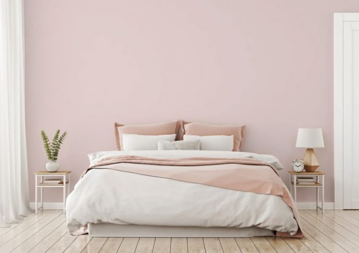 Tintas Eucatex dá dicas sobre como as cores podem influenciar o humor na quarentena. Quarto com a parede de fundo pintada de rosa clarinho,cortinas brancas e cama de casal com lençóis branco e rosa 