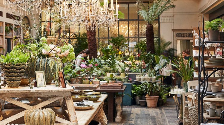 Loja Petersham Nurseries em Covent Garden, Londres, Ambiente da loja com mesas em madeira repleta de vasos e plantas e flores