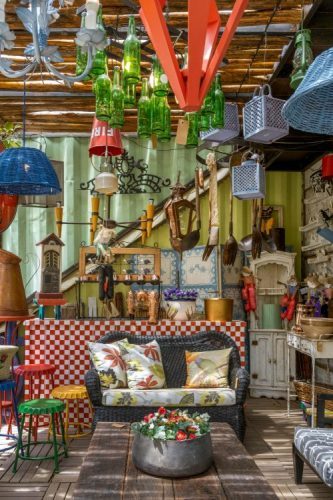 Loja de decorção em Itaipava, dentro de um container. Ambinete com muitos objetos, lustres diversos pendurados e paredes coloridas