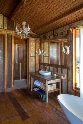 Interior de uma casa de campo toda construida em madeira de demolição e decorada com movies rusticos