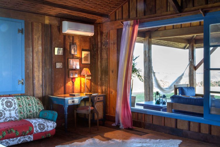 Interiores de uma casa de campo. Toda construida em madeira de demolição com janelas azuis e movies rusticos