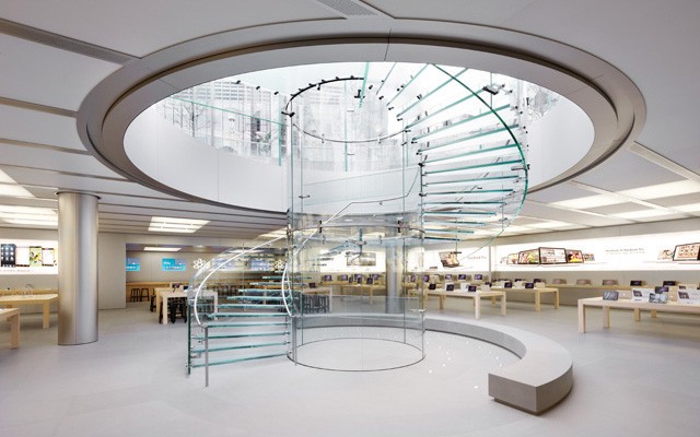 Lúdica e funcional, a magia das escadas helicoidais. Escada toda em vidro dentro de uma loja da Apple. Formato escultural