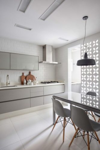 O cobogó é um elemento da arquitetura e design brasileiros. Na cor branca o elemento vazado ciando uma parede para separar a cozinha da area de serviço.