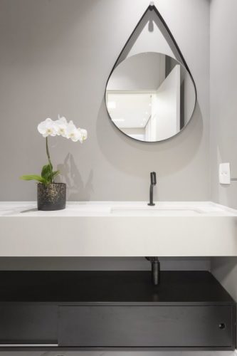 O espelho Adnet na decoração já virou um clássico, no lavabo em cima da bancada branca