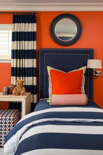 O poder das cores na decoração, quarto com parede laranja, cabeceira em azul jeans e cortina listrada de azul e branco