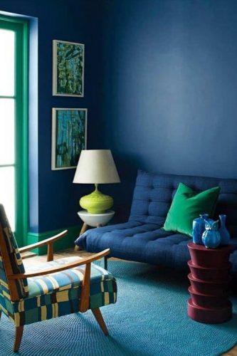 O poder das cores na decoração, sala com parede azul, sofá azul e janela pintada de verde.
