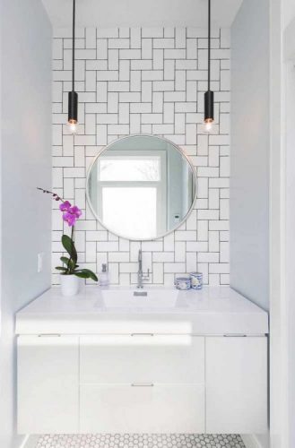 AZULEJO DE METRÔ: IDEIAS PARA SE INSPIRAR,na parede de fundo da bancada do banheiro, paginação espinha de peixe com rejunte preto, espelho redondo e bancada branca