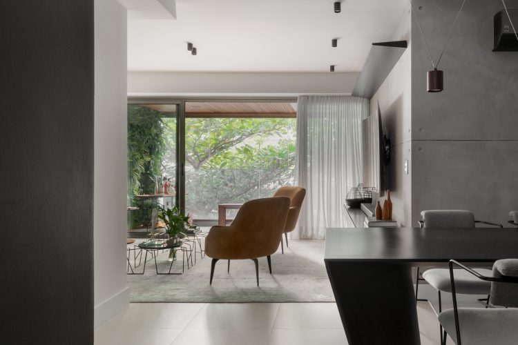Apartamento no Leblon com décor minimalista e brutalista. Sala com varanda e cortina em linho branco. mesa preta 