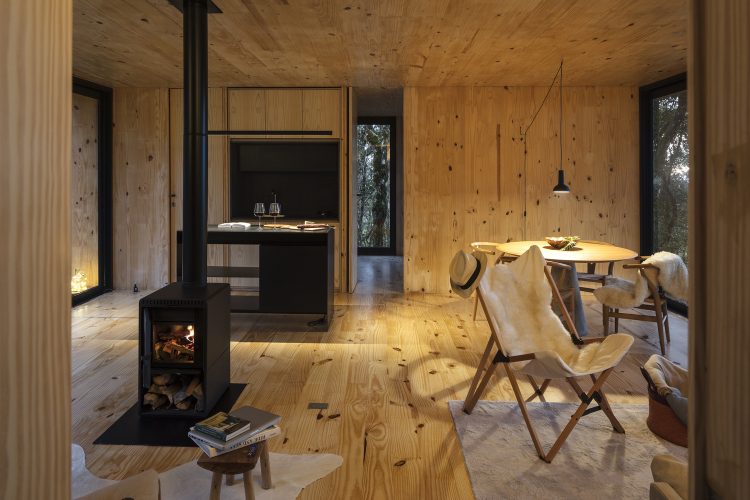 Casas Modulares, sistemas pré-fabricados . Ambiente de estar todo em madeira. piso, paredes e teto. Com uma mini lareira 