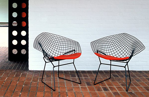 Duas cadeiras em metal tramado na ocr preta com assento em almofada vermelha