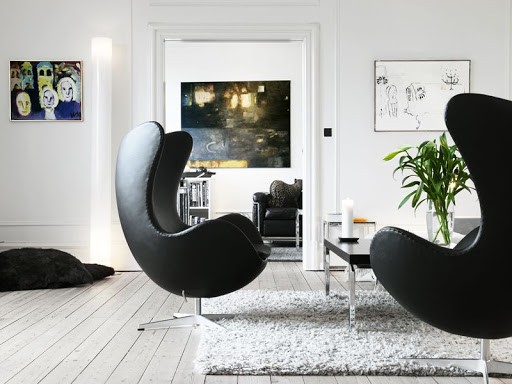 seleção de 10 cadeiras icônicas do design, Egg Chair. Poltrona grande na cor preta em uma sala toda branca