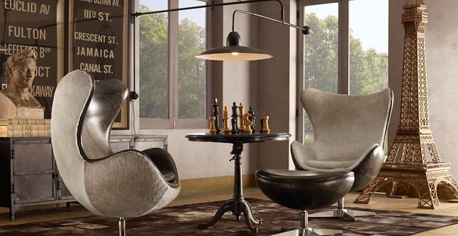 seleção de 10 cadeiras icônicas do design, Egg Chair. Duas poltronas na cor bege, grandes e uma mesa redonda com jogo de xadrez no meio