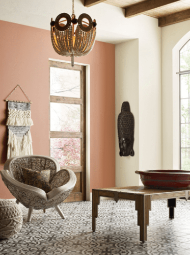 parede com cor salmon e uma cadeira de palha