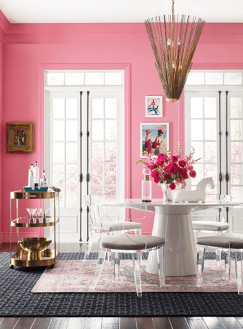 sala clara com duas portas e essa parede pintada de rosa , Mesa redonda branca e cadeiras transparentes