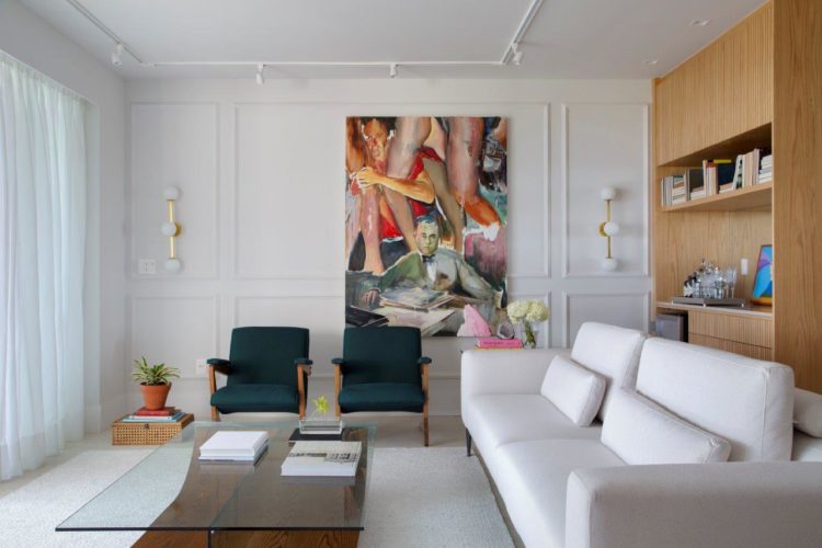 Apartamento de 300 m2 com décor contemporâneo. Sala com sofá branco, duas poltronas verdes e uma quadro colorido na parede