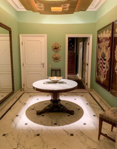 Hall de entada o aparatmento de Costanza Pascolato, paredes verdes, piso em marmore e mesa redonda
