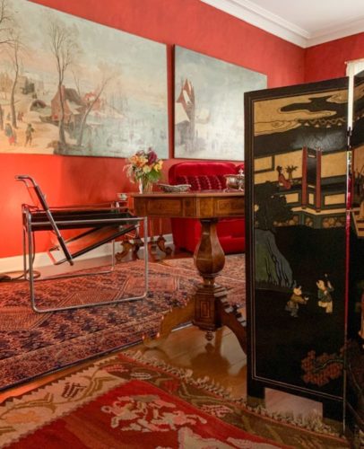 Westwing convida Costanza Pascolato para assinar curadoria. Sala com paredes vermelhas e tapetes persas na casa de Costanza Pascolato