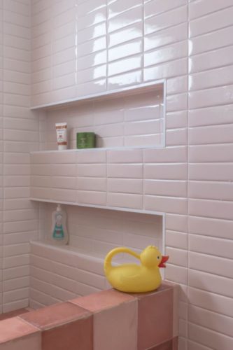 Box de banheiro revestido com azulejo rosa clarinho do formato retangular aplicado na horizontal
