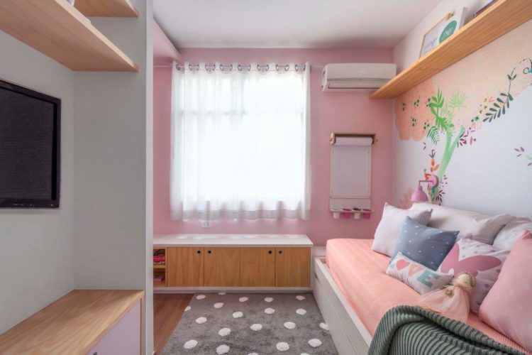 Quarto de menina decorado na cor rosa pintado nas paredes e atras da cama papel de parede florido