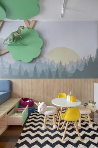 Espaço para crianças, com mesa e cadeiras infantis. papel de parede com floresta ao fundo.