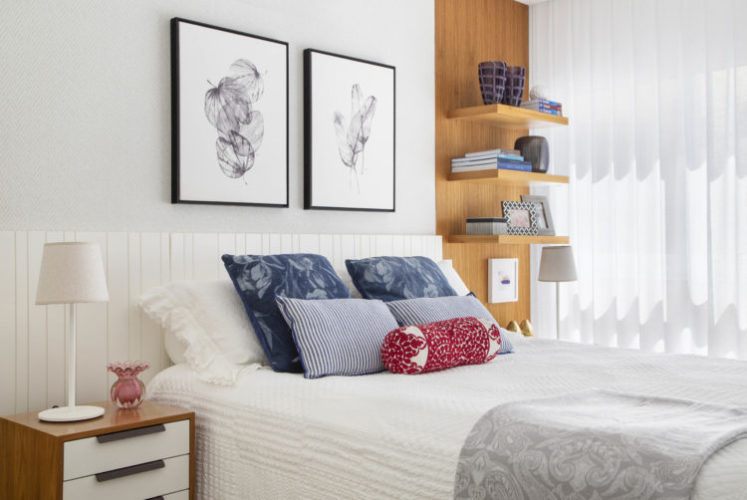 Décor sob medida para apartamento recém-alugado, cabeceira da cama em madeira com laca na cor branca e ao lado uma faixa em madeira com prateleiras