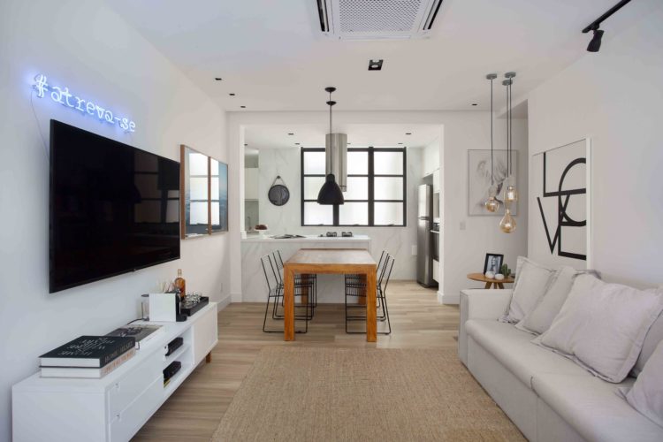 Apartamento de 90m², no Leblon, ganha acessibilidade em reforma. Sala com circulação bastente livre, cozinha aberta para a sala.