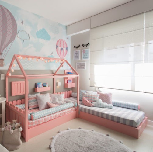 Quarto Montessoriano. Duas camas baixas, com base na cor rosa e uma delas com desenho de casinha.