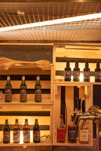 caixotes de madeira com garrfas de cerveja decoram o bar