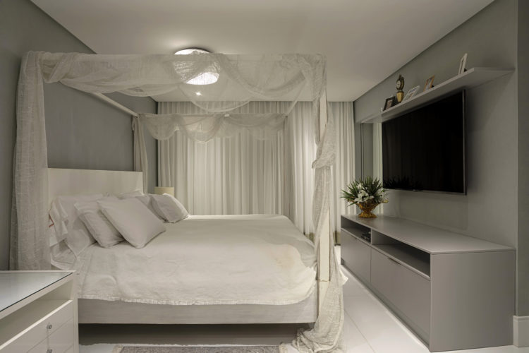 Cobertura em Salvador, quarto de casal com cama branca com dossel e voal branco.