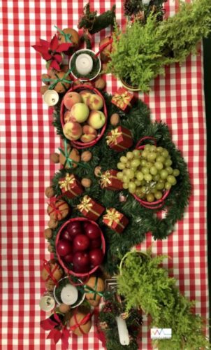 Mesa de Natal, com toalha xadrez branco e vermelho, cestos com frutas 