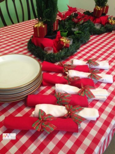 Mesa de Natal com toalha xadrez branco e vermelho , guardanapos com laços 