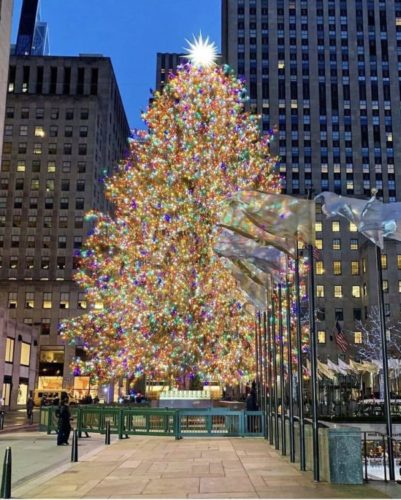 Árvore na Natal do Rockefeller Center, em Nova York. Enorme e repleta de luzes amarelas no centro da praça