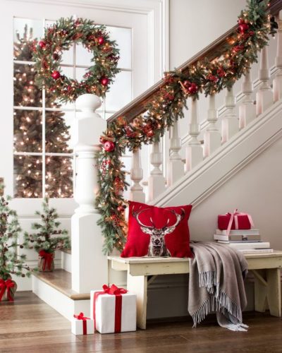 Prontos para decorar casa para o Natal?. Corrimão da escada enfeitado com cordão verde e bolas vermelhas.