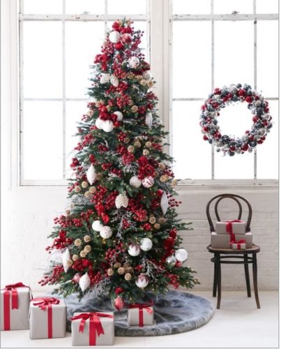 Paredes com tijolinho branco, contraste com a arvore de Natal com bolas vermelhas e no piso pacotes de presentes