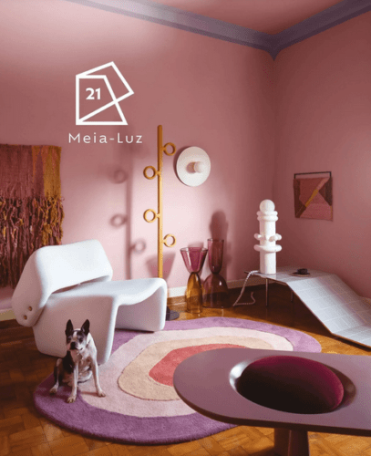 As cores de 2021 eleitas pelas Tintas Suvinil meia Luz, um rosinha. Sala com as paredes nessa cor e um tapete redonso com tons rosa