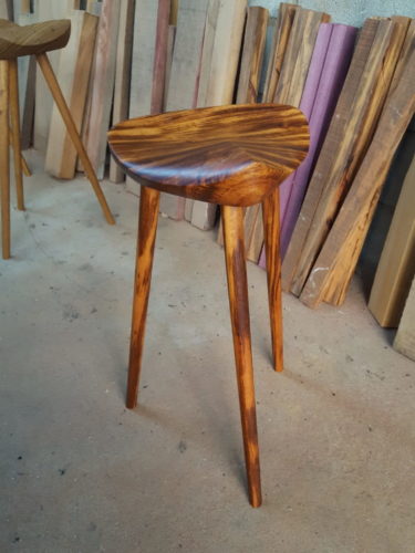 Banco sela do designer carioca Ricardo Graham, em madeira. Assento que lembra uma sela de cavalo e tres pés finos