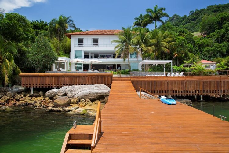 Em Angra, a mais perfeita tradução do paraíso.Casa na costa verde, branca com tres andares e um longo deck de madeira na frente