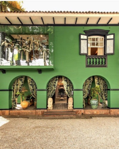 fachada da loja Entreposto, frete toda pintada de verde. tres arcos na entrada com cortinas nas laterias