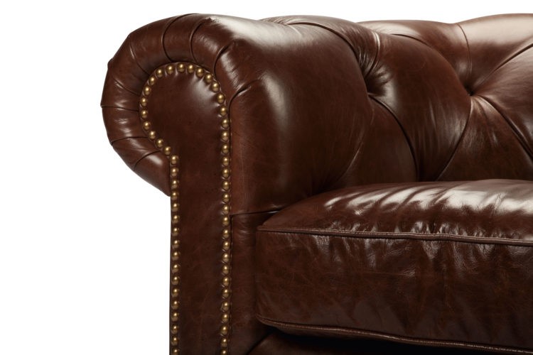 sofá Chesterfield, aquele grande, confortável e capitonê (ou botonê, cheio de botõezinhos),, marrom em curo e braços arredondados com tachas douradas