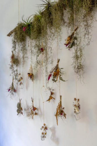 Arranjo de flores e plantas formando um arranjo na parede 