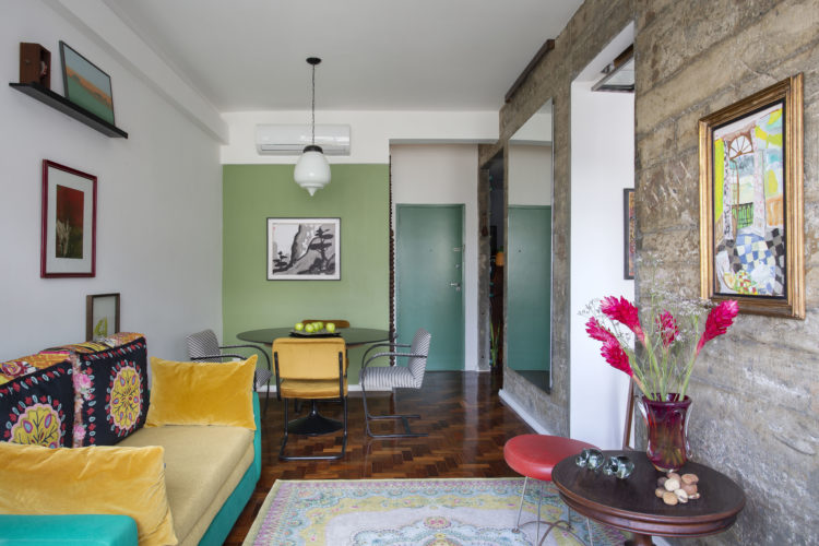 O estilo "de tudo um pouco" no novo apartamento do arquiteto Francisco Palmeiro. Espaços integrados, parede de pedra , parede pintada de verde e um sofá amarelo