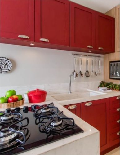 Cozinha com armários na cor vermelha, bancada branca